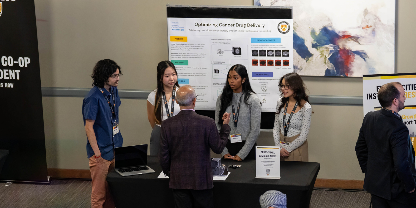 Four students stand at a booth, in front of their i-Capstone poster, talking to a person at a University of Waterloo event.