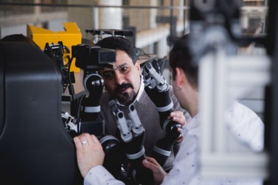 William Malek working with a robot