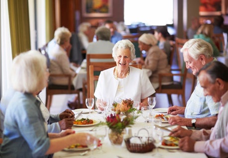 Older adults sitting at dining table.