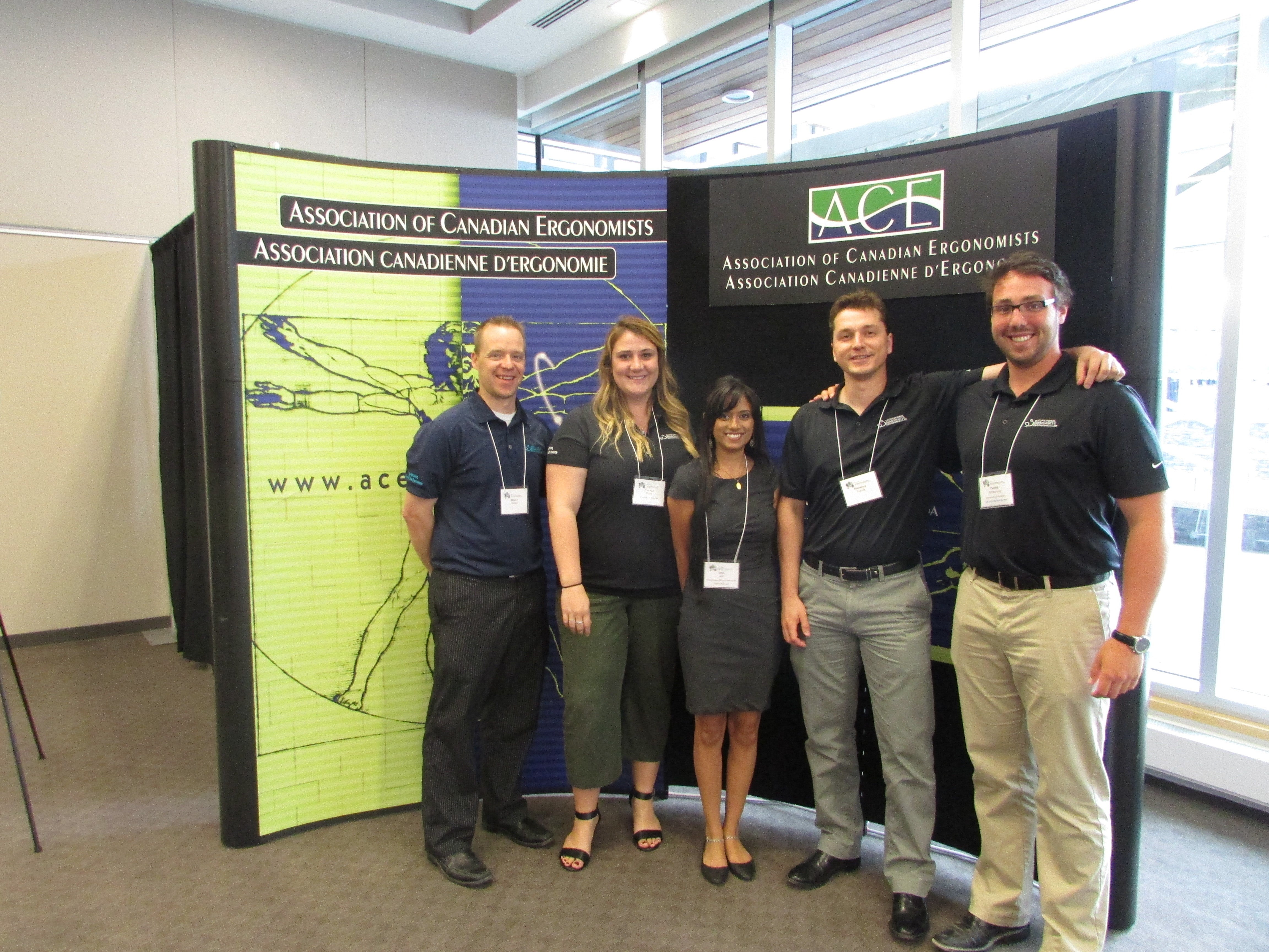 Lab members posing in front of the Association of Canadian Ergonomists banner
