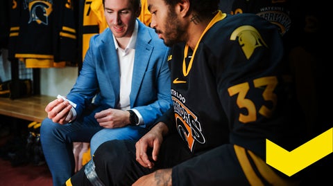 Two people sitting in hockey locker room looking at test