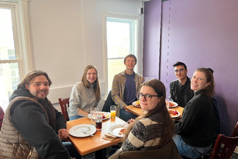 People sitting and smiling at a table with food