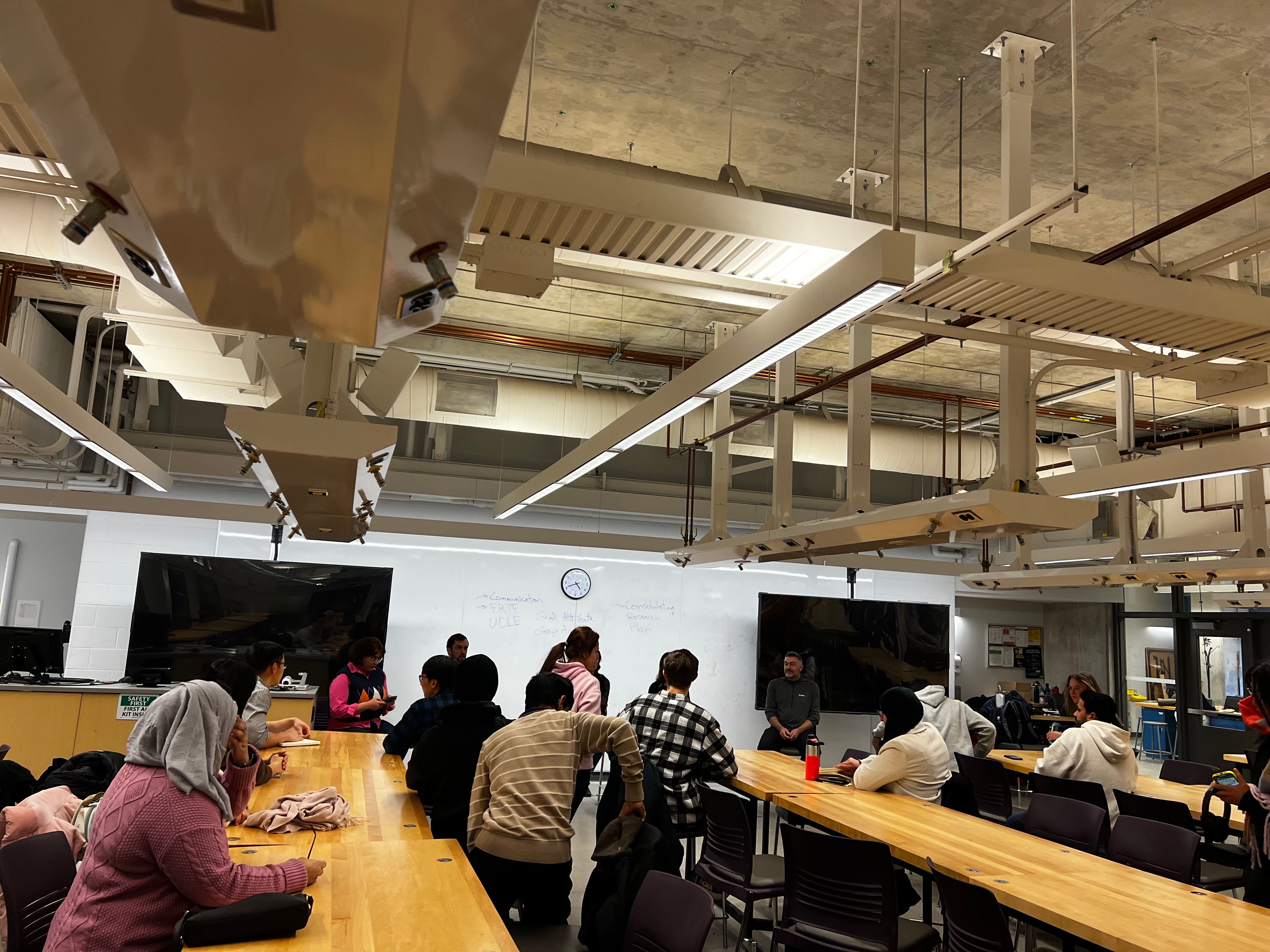 Image of the panel event organized, students sitting at tables listening to the panel