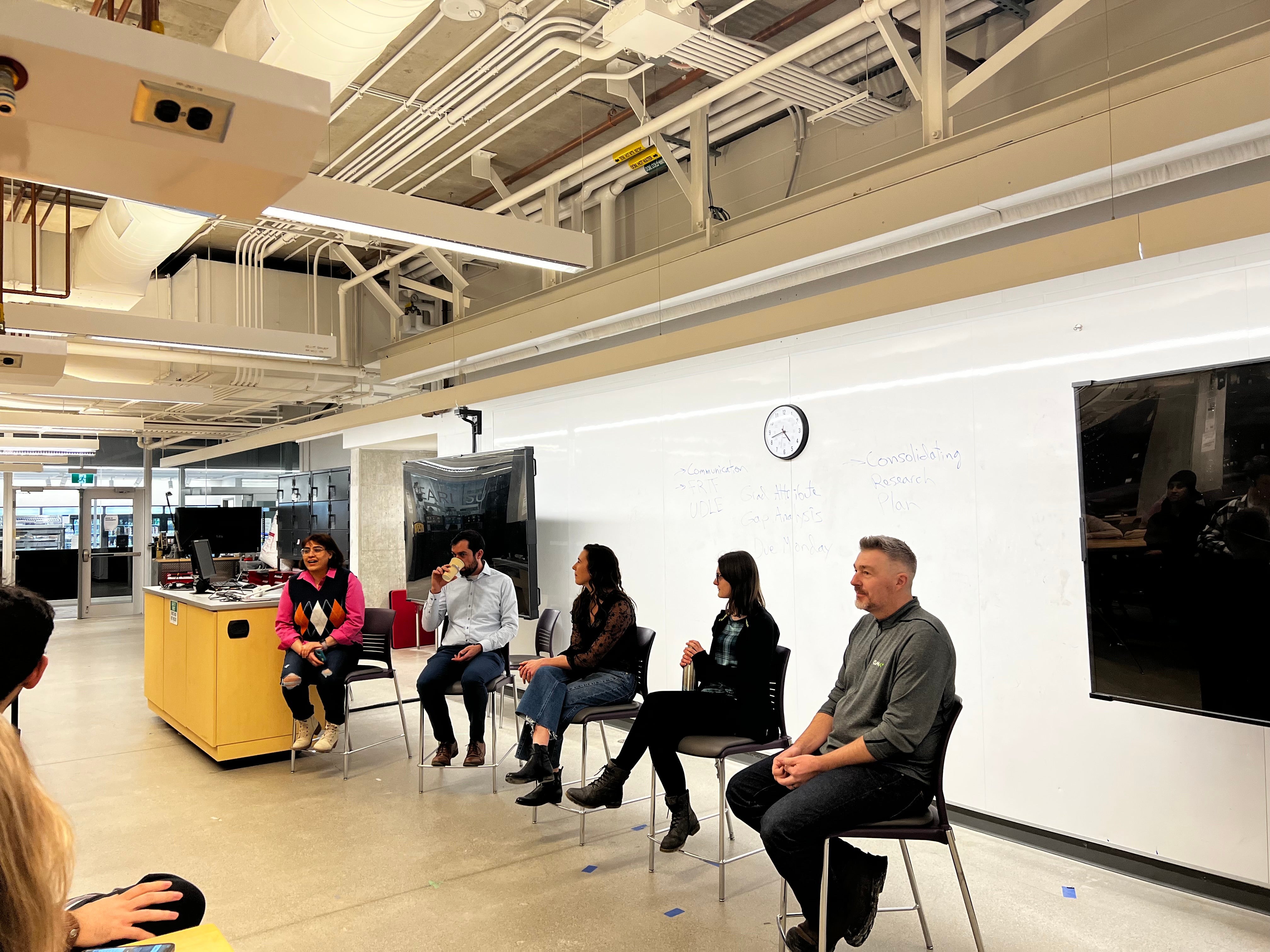 Image of the panel event organized, students sitting at tables listening to the panel