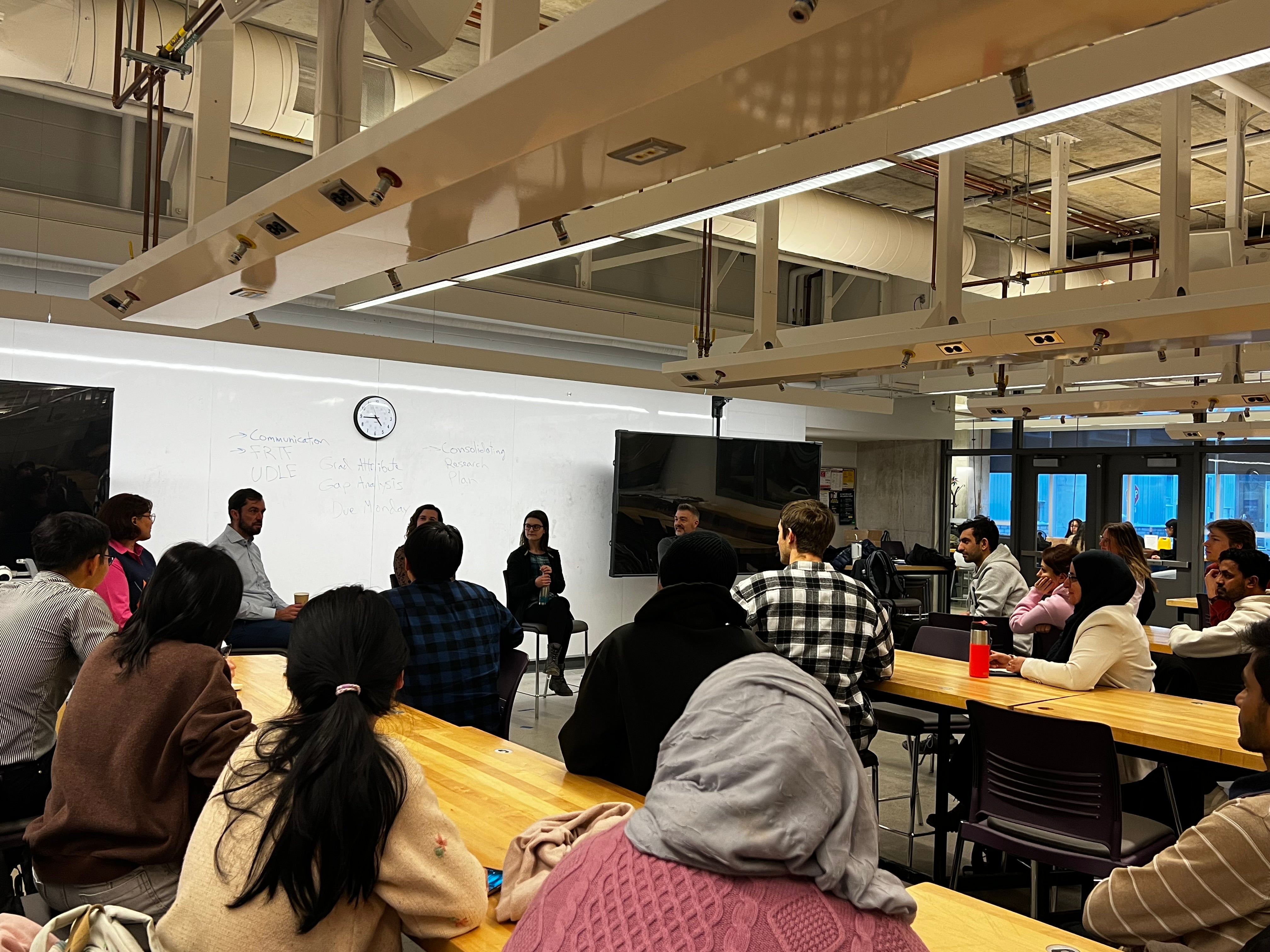 Image of the panel event organized, students sitting at tables listening to the panel