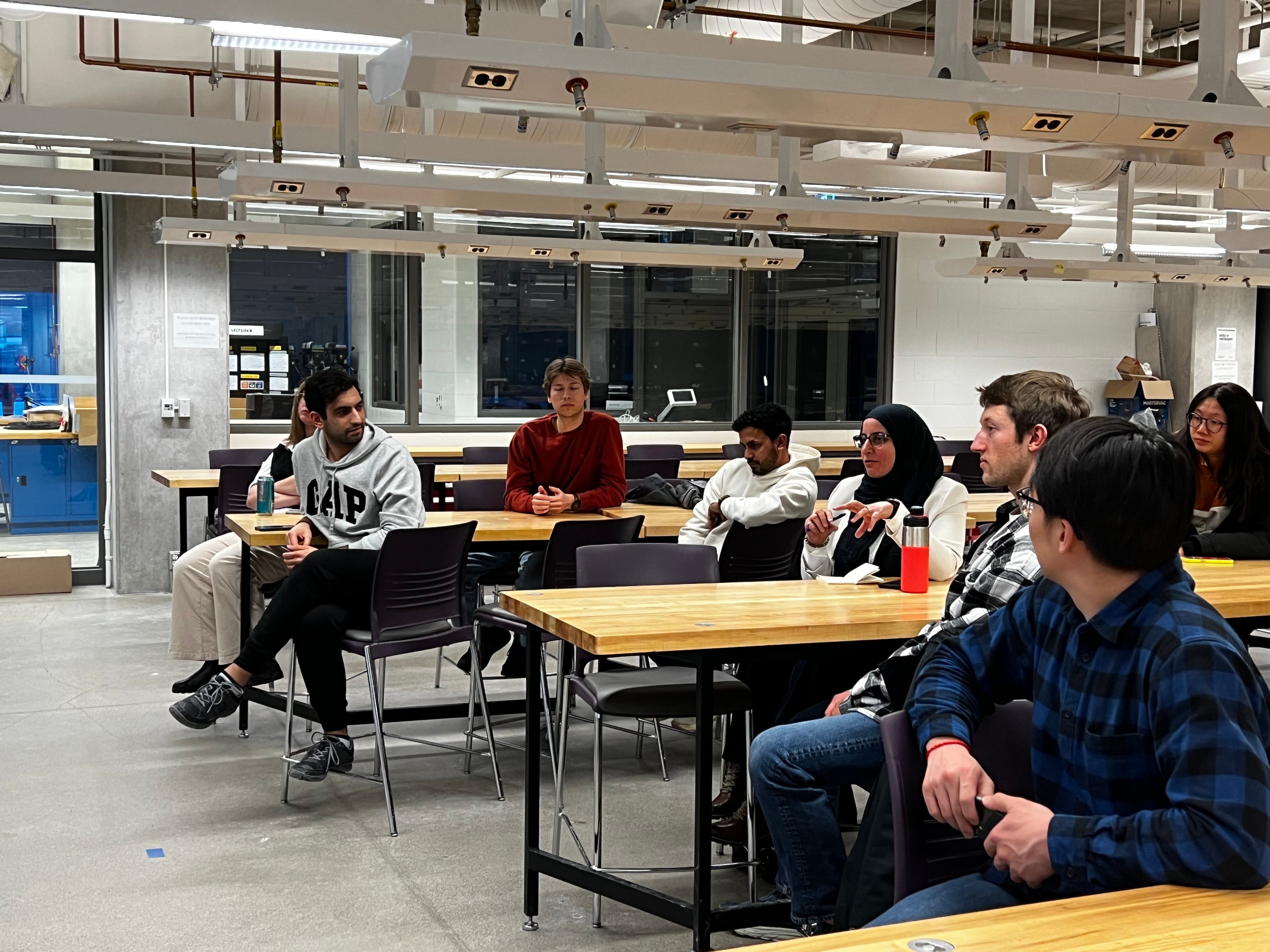 Image of the panel event organized, students sitting at tables listening to the panel