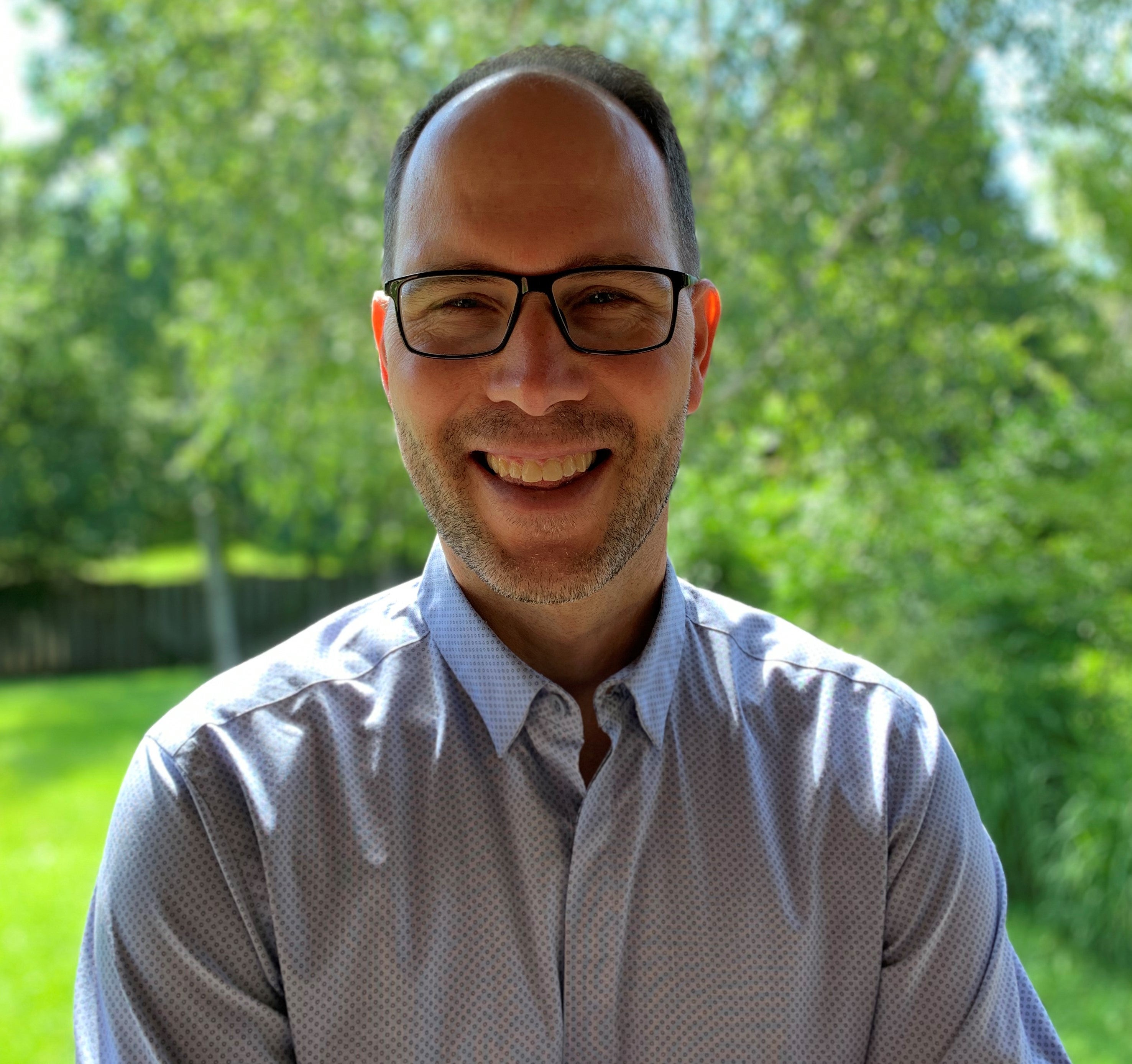 John Johnston, smiling, taken on a sunny day outdoors