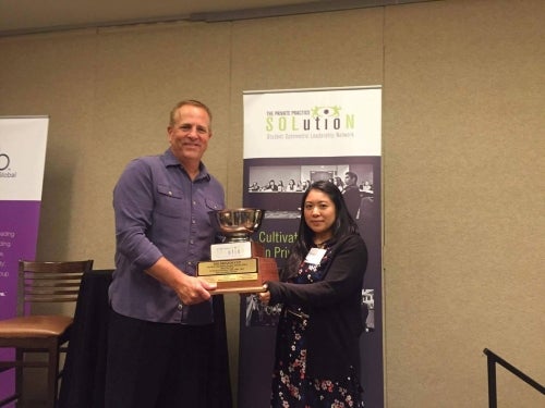 School of Optometry and Vision Science student, Jaclyn Chang, accepts this year's award for the University of Waterloo Advancement of Independent Optometry Club (UWAIOC) 