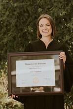 Olivia Young holds her newly framed diploma for Doctor of Optometry