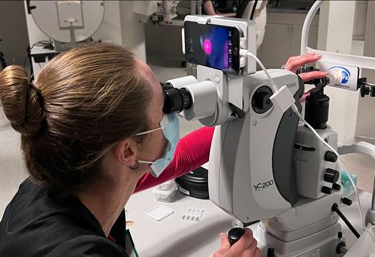 Optometrist looks through a slit lamp