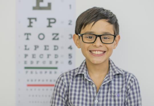 Child in front of eye chart