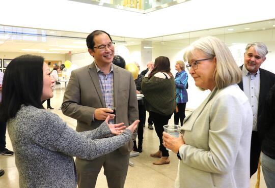 Drs. Lisa Christian, Stan Woo and Patty Hrynchak chat together at a reception