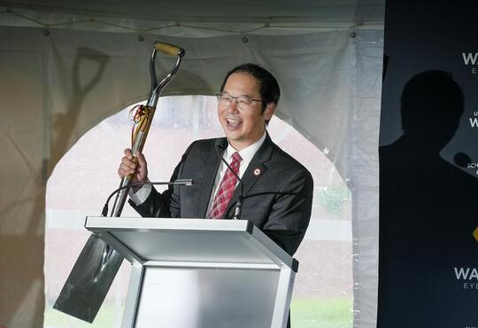 Stan Woo holds up the shovel that was originaly used to break ground on the School