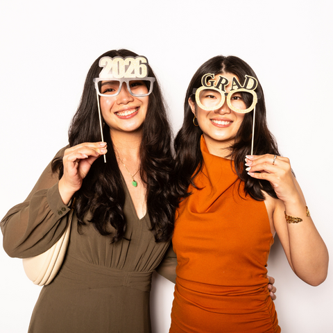 two girls looking at camera with photoshoot prop glasses