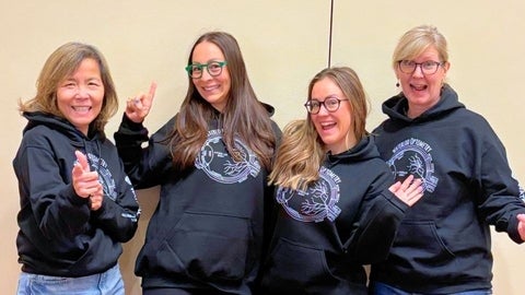 Four women in optometry hoodies