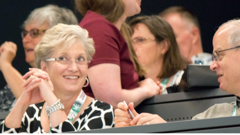 Smiling woman and man talking in lecture hall