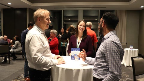 Attendees at last year's alumni weekend laugh and chat together