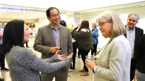 Drs. Lisa Christian, Stan Woo and Patty Hrynchak chat together at a reception