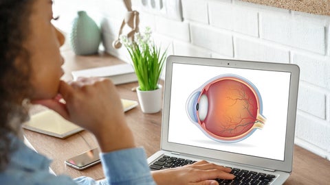 Young woman looks at laptop screen displaying an eye diagram