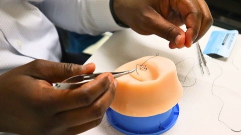 A student practices suturing