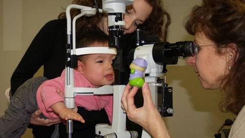 Dr. Sue Leat examines a child in a lab setting