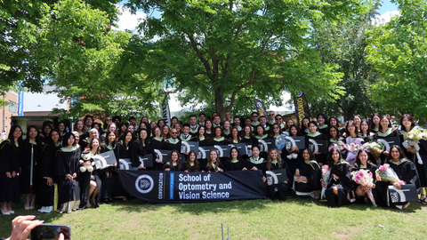 Group photo of class of 2026 on on grass with trees in back