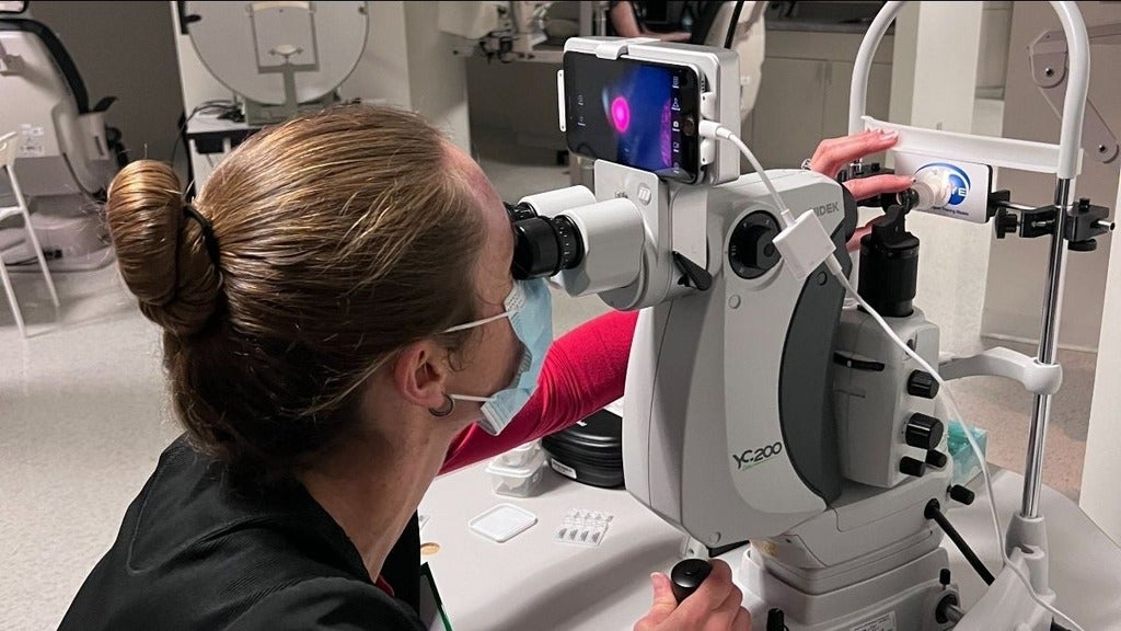 Optometrist looks through a slit lamp
