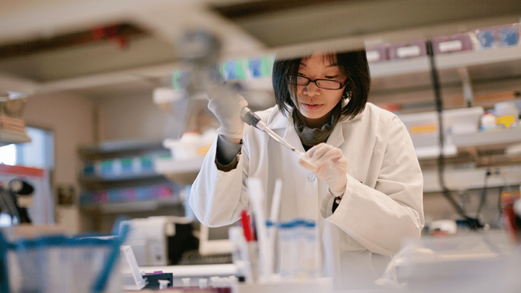 A female researcher drips liquid into a test tube