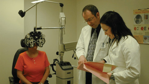 Dr. Kenneth Hadley in clinic with a student and patient