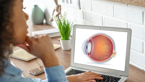 Young woman looks at laptop screen displaying an eye diagram