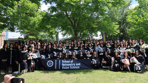 Group photo of class of 2026 on on grass with trees in back