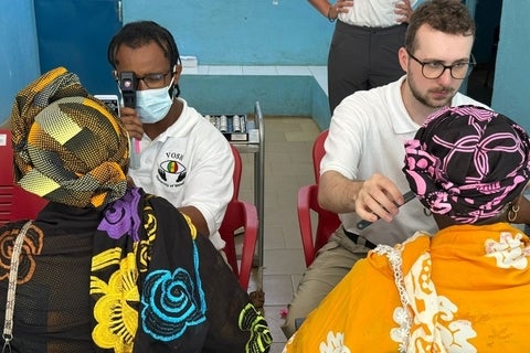 Two optometry students from VOSH performing eye exams.