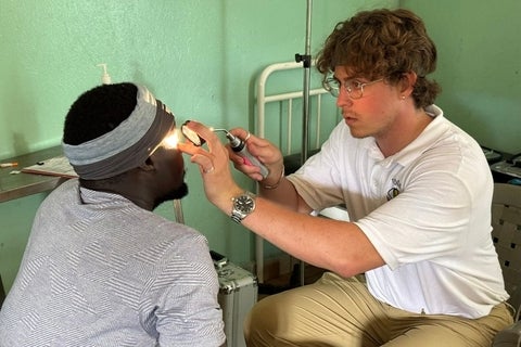 Owen Alstad performing an eye exam.