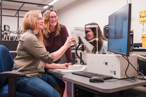 Three women using imaging equipment