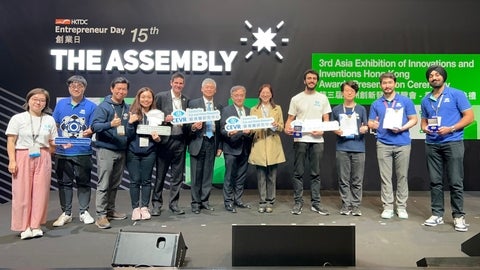 Group of people from CEVR on stage at Hong Kong exhibition of inventions