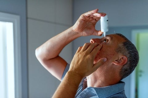 Man putting in eye drops