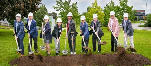 Local leaders and the WEI steering committee dig in the earth with shovels to commemorate the ground breaking ceremony