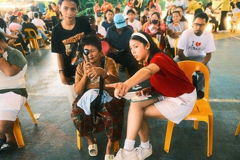 Nicole Shanta seated next to a woman, testing her visual acuity.