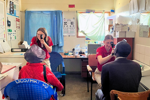 Emma Coughlan and Vanessa Mucz preforming eye exams on two individuals.