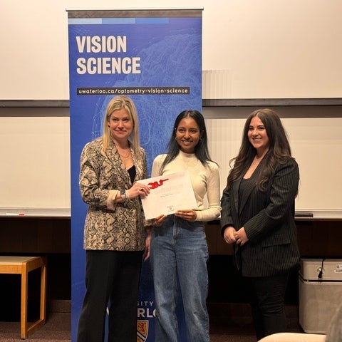 Award presenters with student holding certificate