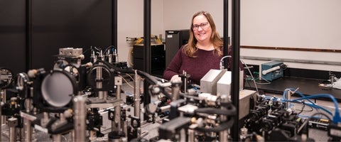 Jennifer Hunter stands behind equipment in her laboratory