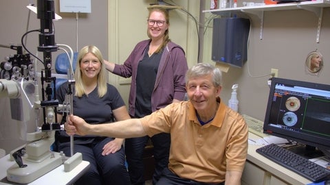 Three people in optometry clinic