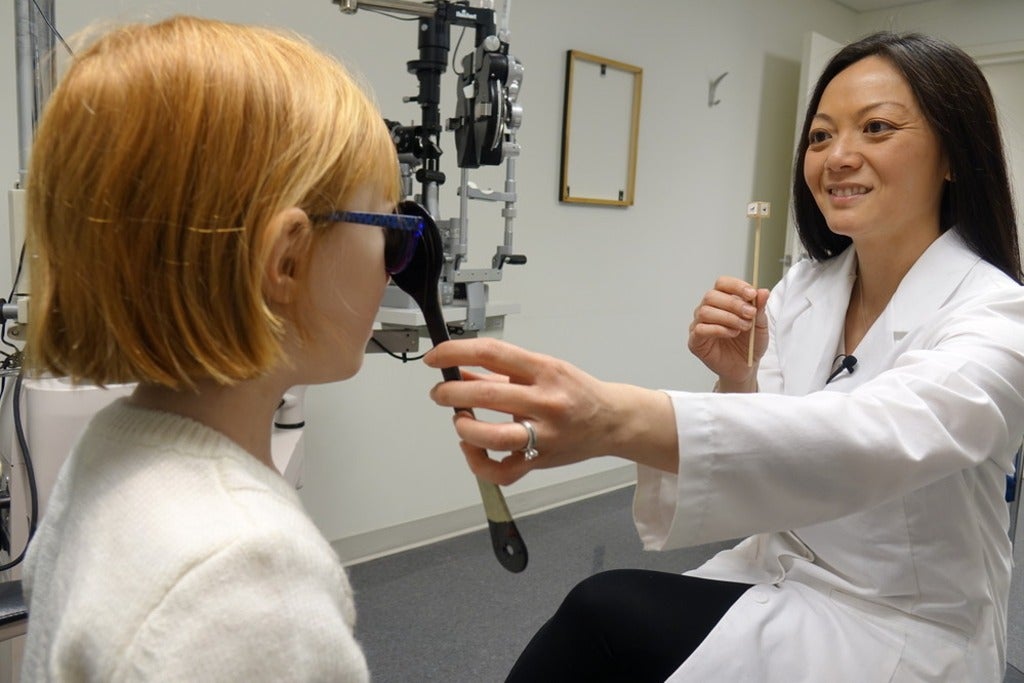 Lisa Christian performing an eye examination on a child