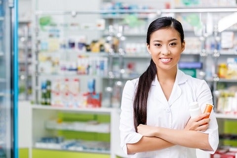 Pharmacist standing with prescription bottles