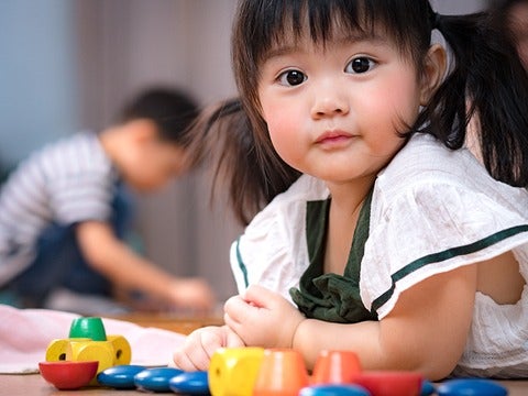 small asian girl with pigtails looks into camera