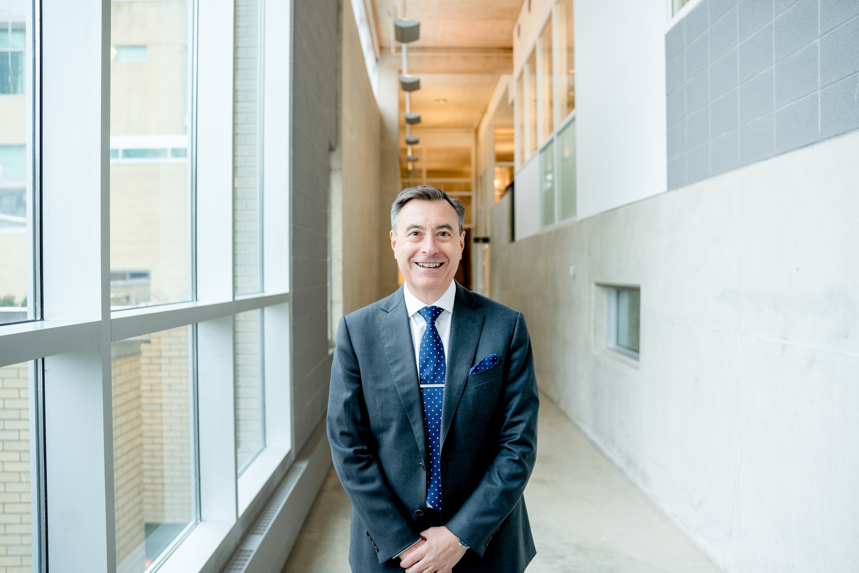 man in grey suit smiling at camera