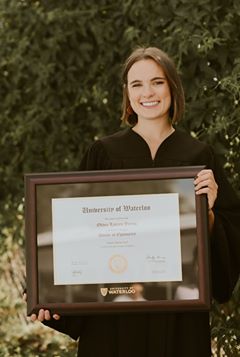Olivia Young holding her newly framed diploma