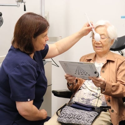 Dr. Tammy Labreche tests the close vision of an older woman