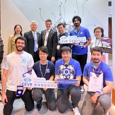 Group of people pose with CEVR signs at international invention fair in Geneva