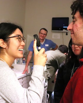 Student gives an eye exam while being supervised